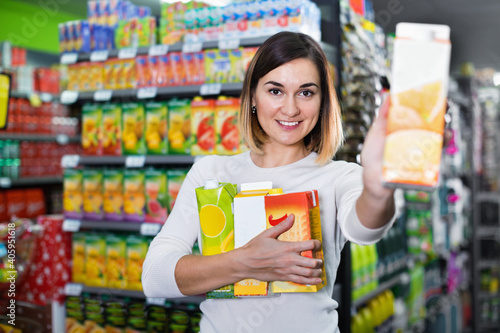 Happy woman choosing refreshing beverages in supermarket