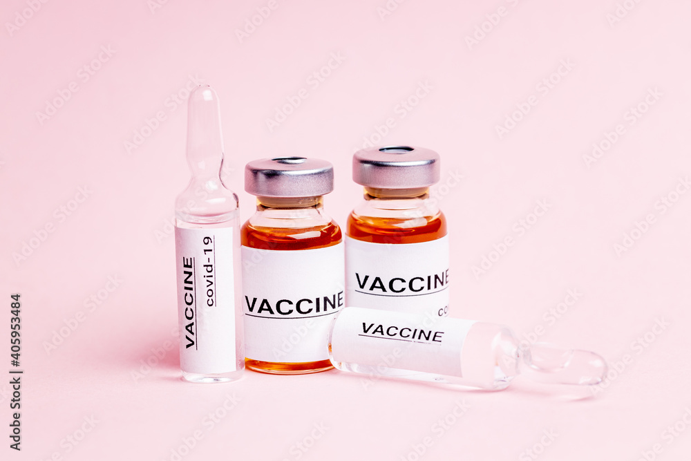 abstract vaccine vials and bottles for injection over pink background. alarm clock near vaccination drugs. vaccination concept abstract vaccine vials and bottles for injection over pink background. alarm clock near vaccination drugs. vaccination concept