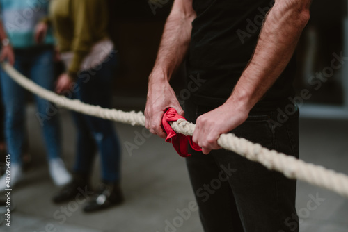 Brazos fuertes que sostienen un lazo rojo en el país vasco jugando a un juego tradicional llamado soca tira..