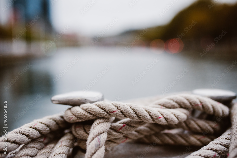 Cuerda blanca gorda en una barco navegando el rio de bilbao en españa con paisaje desenfocado.