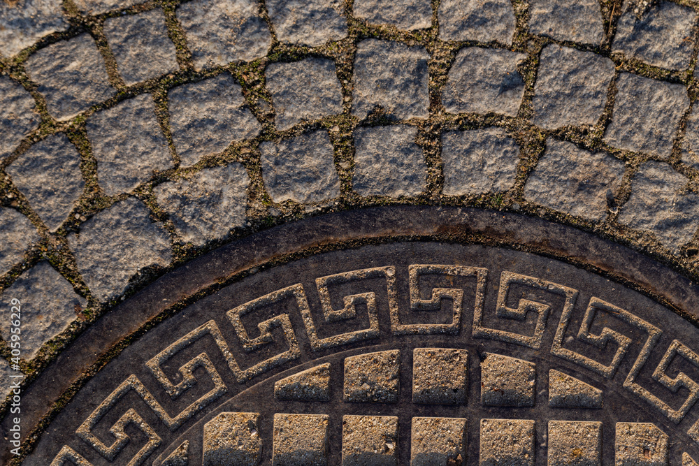 part of a road hatch with Greek ornament on a stone road