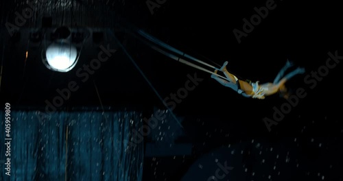 Amazing aerial gymnastics tricks by a young acrobat on a trapeze, danger, 4k