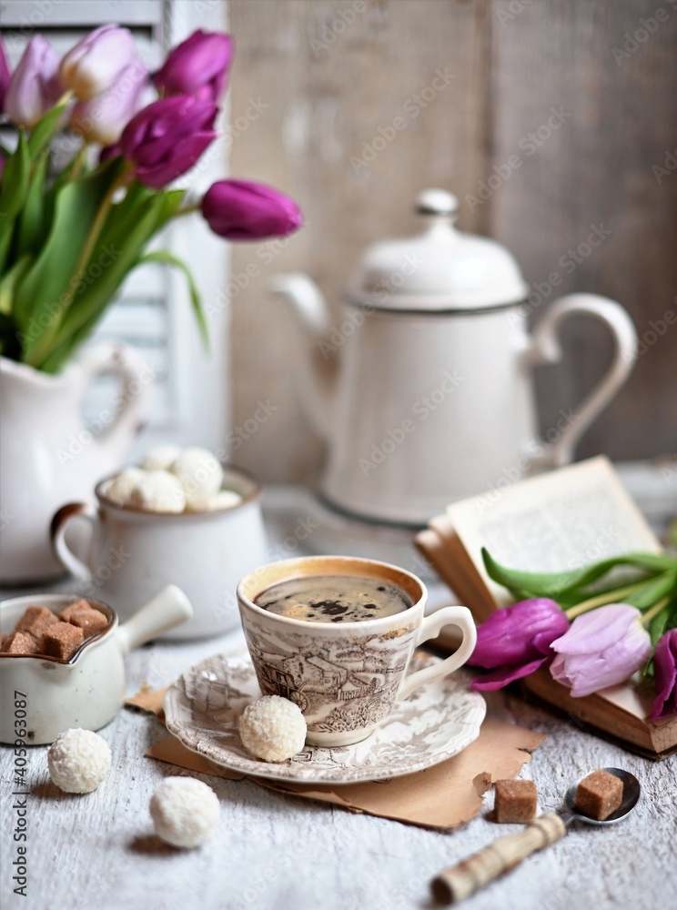 Cup of coffee with sugar cubs and coffee pot. Coffee cup, spring tulip flowers. Cup of coffee with sugar cubs and coffee pot. Coffee cup, spring tulip flowers.