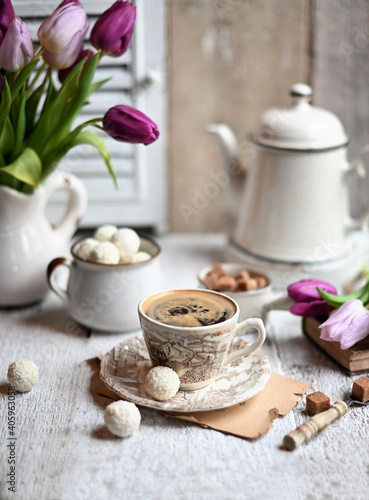 Cup of coffee with sugar cubs and coffee pot. Coffee cup  spring tulip flowers.