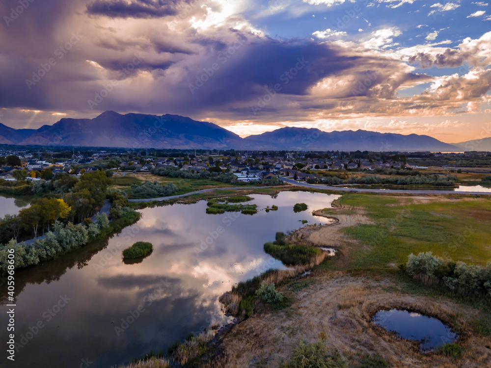 Obraz premium Dramatic clouds over a mountain landscape are reflected on the lake - aerial