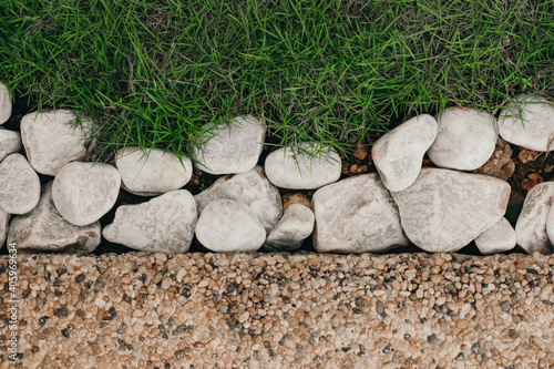 Background with the contrast of pebblestones white rocks and bright green grass photo