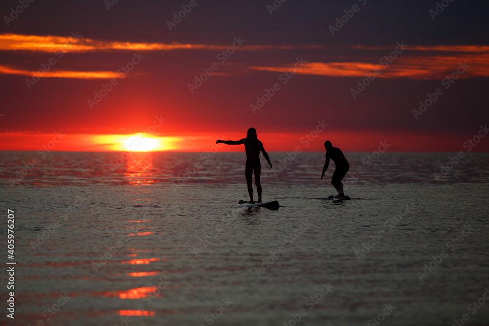 People surfing at sunset.
