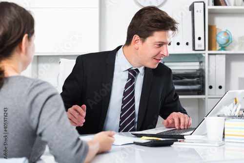 фотографія Portrait of young smiling man with companion sitting at the table