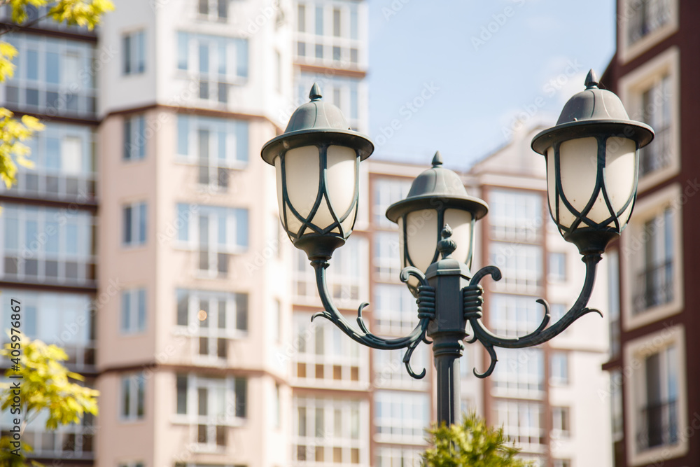 Beautiful lantern on background of new-constructed multi-storey houses. Stylish residential quarter. New family life in the city. Light in the life. Europe building