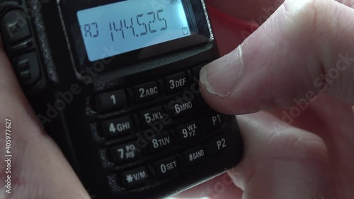 Handheld radio tuning into different frequencies and listening to broadcasts