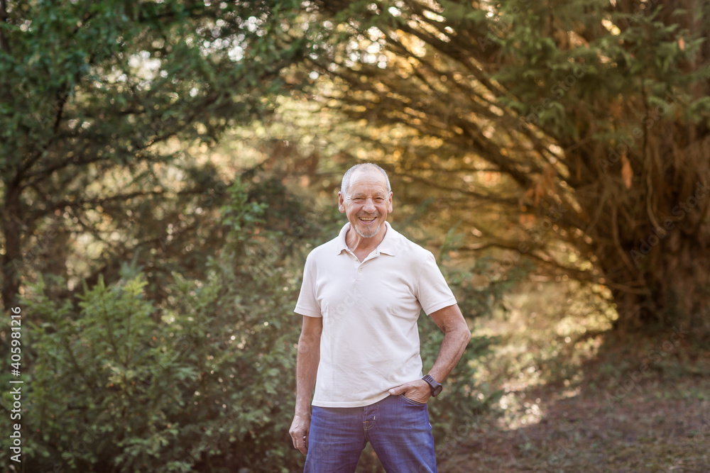 Portrait of happy and smiling senior man taking a walk in the countryside Portrait of happy and smiling senior man taking a walk in the countryside