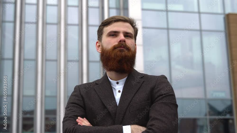 Portrait of an handsome businessman wearing jacket over office building in financial district outdoors. Young bearded Businessman outdoor. Successful entrepreneur dressed in formal wear. Portrait of an handsome businessman wearing jacket over office building in financial district outdoors. Young bearded Businessman outdoor. Successful entrepreneur dressed in formal wear.
