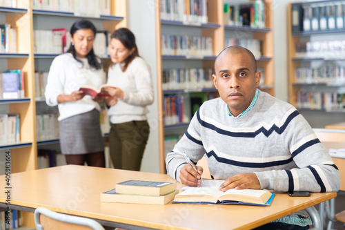 Adult male student working in library, concept of adult education