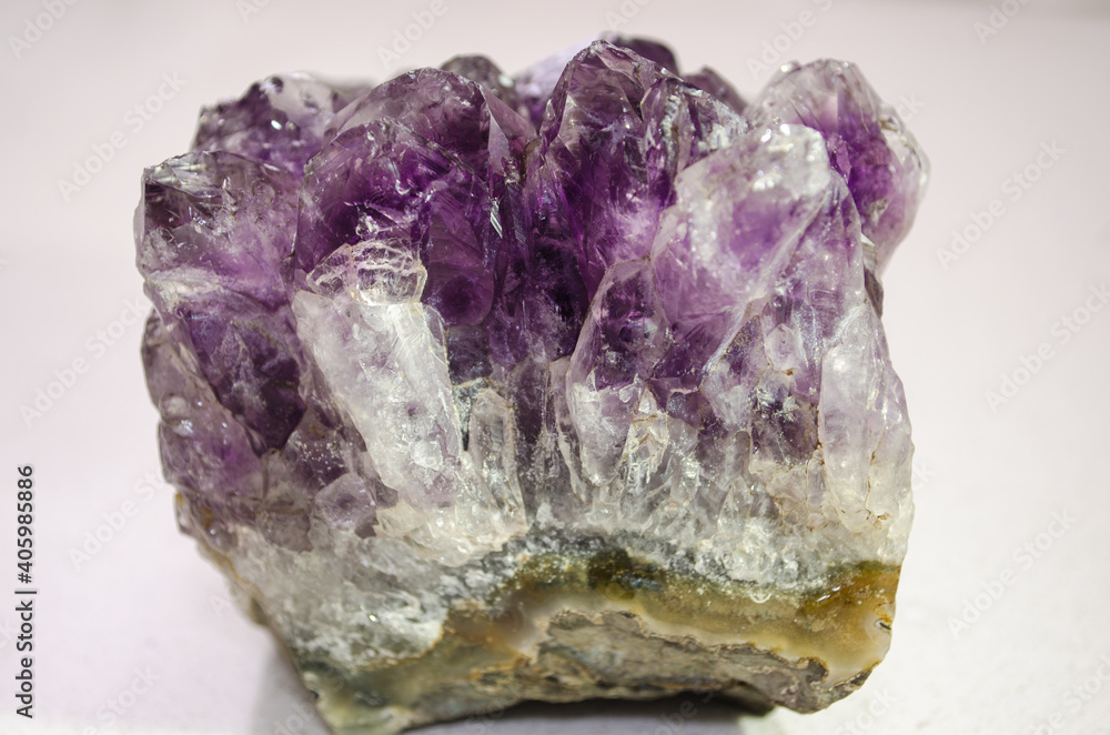 Selective focus of purple amethyst stone on white background.