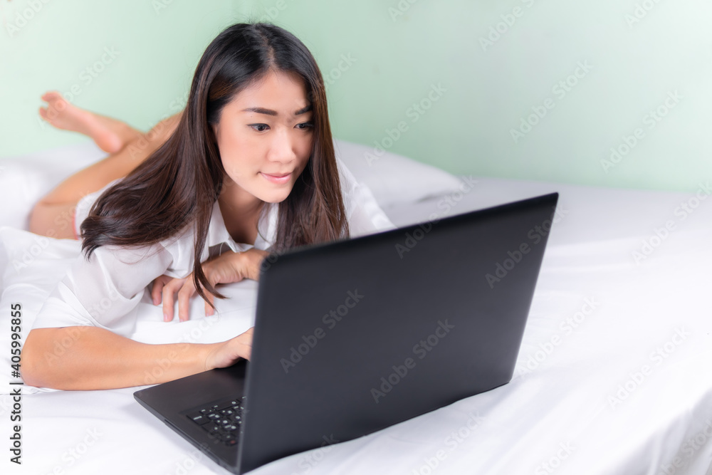 Young asian women use laptop computers at home in the bedroom. work from home concept.. Young asian women use laptop computers at home in the bedroom. work from home concept..