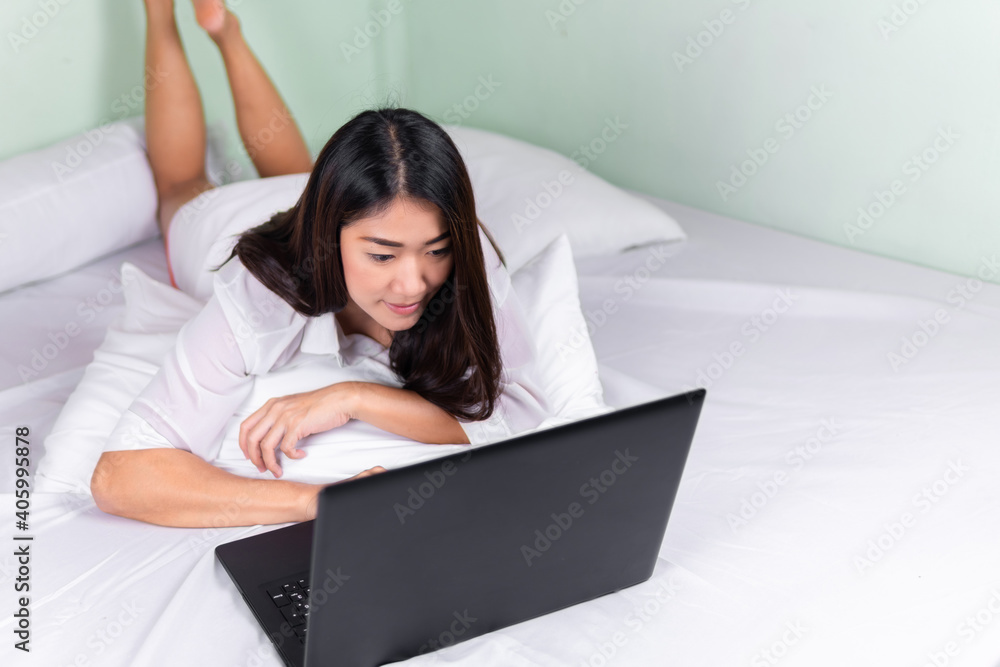 Young asian women use laptop computers at home in the bedroom. work from home concept. Young asian women use laptop computers at home in the bedroom. work from home concept.