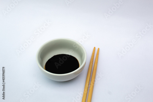 A bowl of oyster sauce and chopsticks.