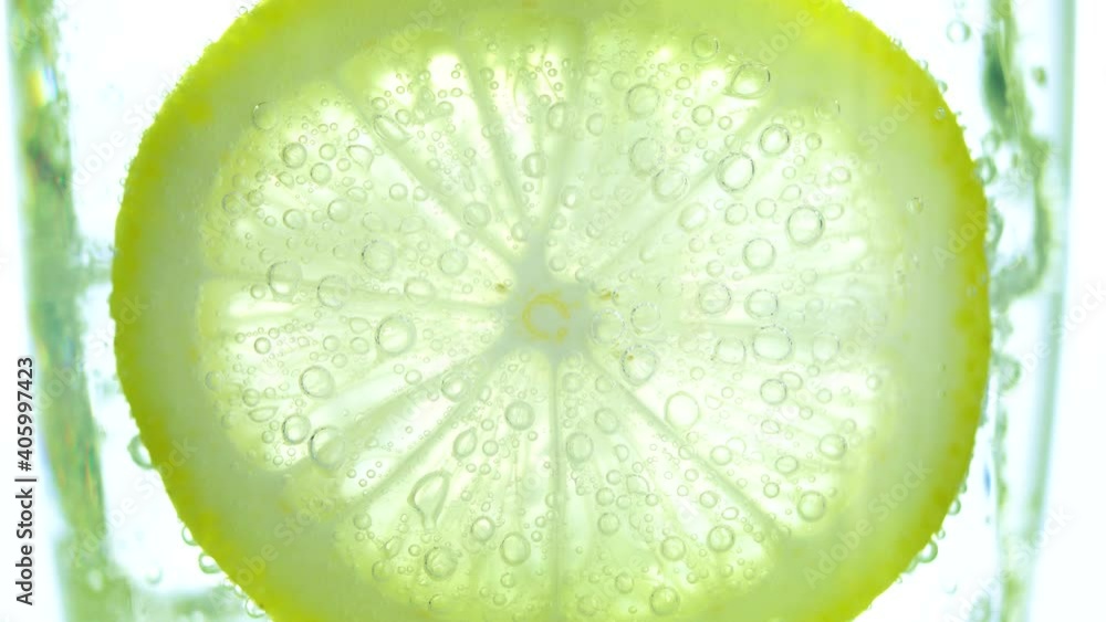 Macro close-up concept, Slice of lemon with bubbles of soda water in the glass , Refreshing cold cocktail with lemon. Macro close-up concept, Slice of lemon with bubbles of soda water in the glass , Refreshing cold cocktail with lemon.