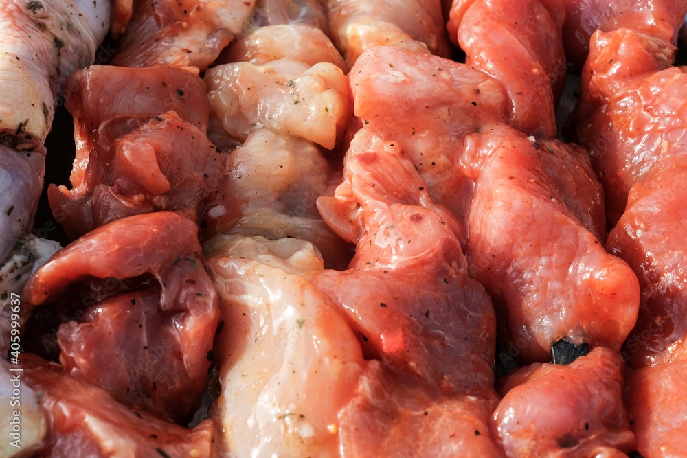 Raw pork skewers and chicken thighs cut into pieces and on skewers closeup Raw pork skewers and chicken thighs cut into pieces and on skewers closeup