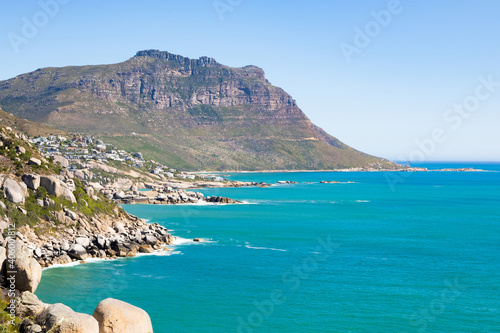 Rocky shore and a calm beautiful seascape view in Cape Town, South Africa under a clear sky