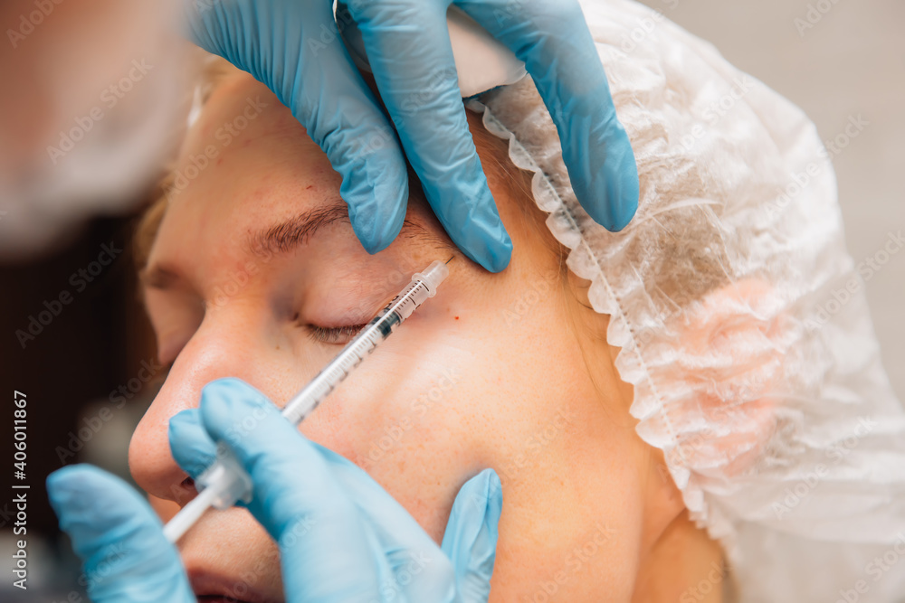 Adult woman with wrinkles around her eyes in process rejuvenation injections of hyaluronic acid filler, close up. Cosmetologist injects botulinum toxin to smooth female face skin. Adult woman with wrinkles around her eyes in process rejuvenation injections of hyaluronic acid filler, close up. Cosmetologist injects botulinum toxin to smooth female face skin.