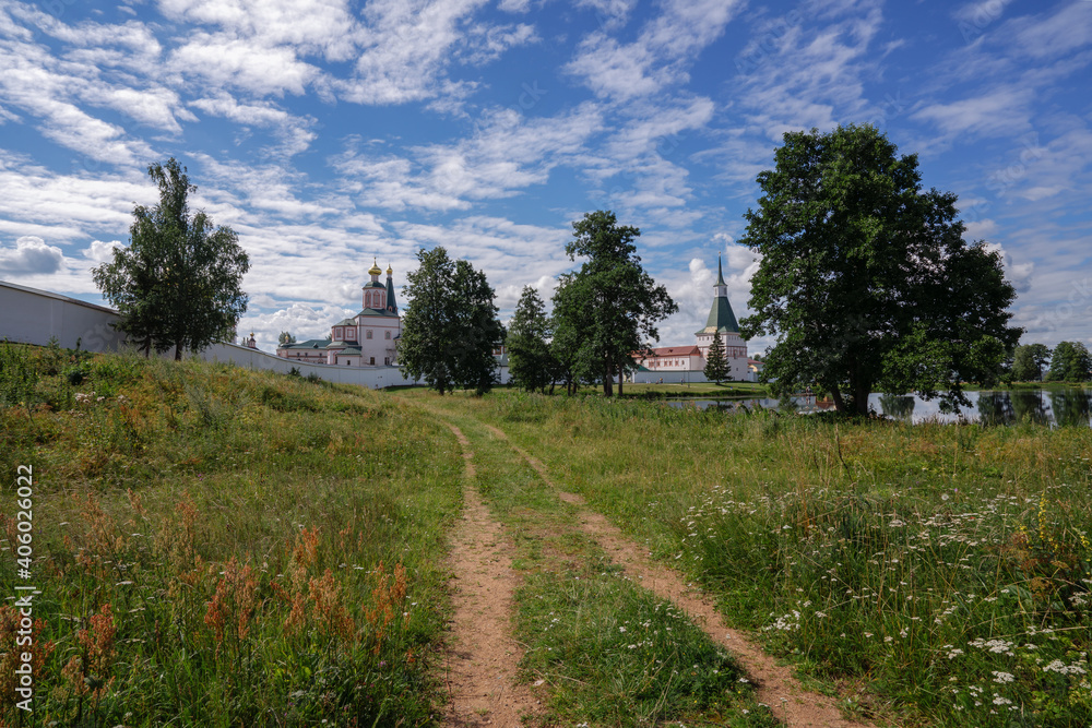 View of the Valday Iversky Monastery and a country road on a sunny summer morning. Valdaysky District of Novgorod Oblast, Russia. August 2020.