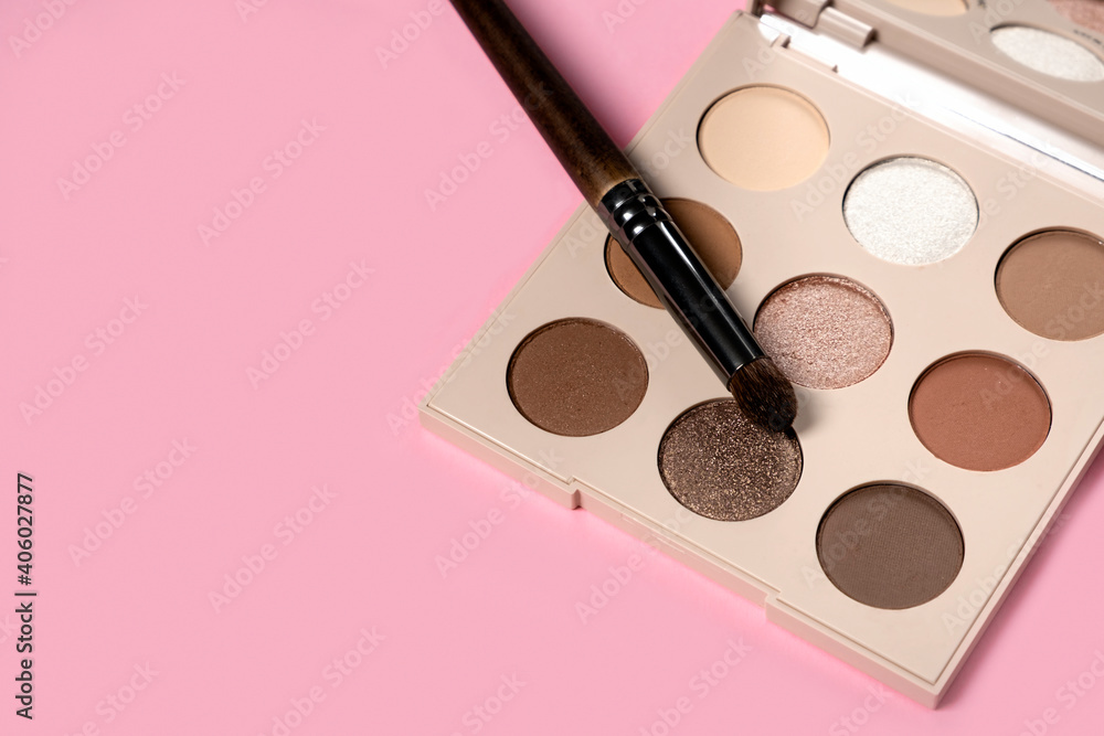  Daily eyeshadow palette in brown tones on a pink background top view with copy space. makeup brush, decorative cosmetics for the face. Flat lay female accessories. Nobody - obrazy, fototapety, plakaty 