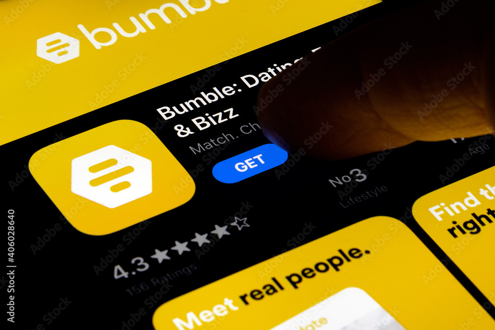 Hand holding a smartphone with a Bumble dating app on apple store at night.  IPhone 11 with a social media Bumble app logo. Find your match. foto de  Stock | Adobe Stock