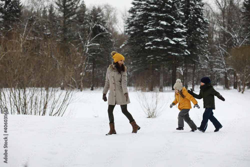 Happy family playing and laughing in winter outdoors in the snow. City park winter day.