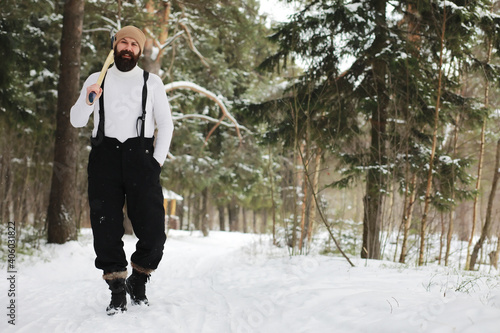 Outdoor portrait of handsome man in coat and scurf. Bearded man in the winter woods. © alexkich