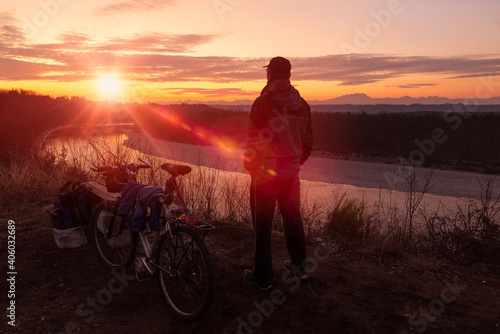 Lonely man with mountain bike at sunset. Concept of adventure, freedom and outdoor recreation. Ticino Park and river Ticino near Castelnovate, Italy © AleMasche72