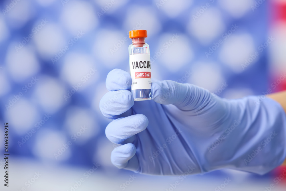 Doctor's hand with COVID-19 vaccine against USA flag Doctor's hand with COVID-19 vaccine against USA flag