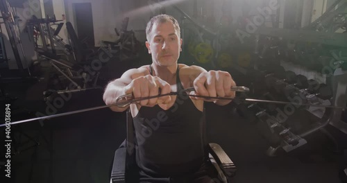 Disabled man in a wheelchair doing physical exercises in the gym. photo