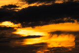 Golden sunset sky with dark clouds. Beauty in nature. Beautiful sunset sky abstract background. Orange and yellow sky with black clouds at dusk. Sky at dusk. Peaceful and tranquil concept.