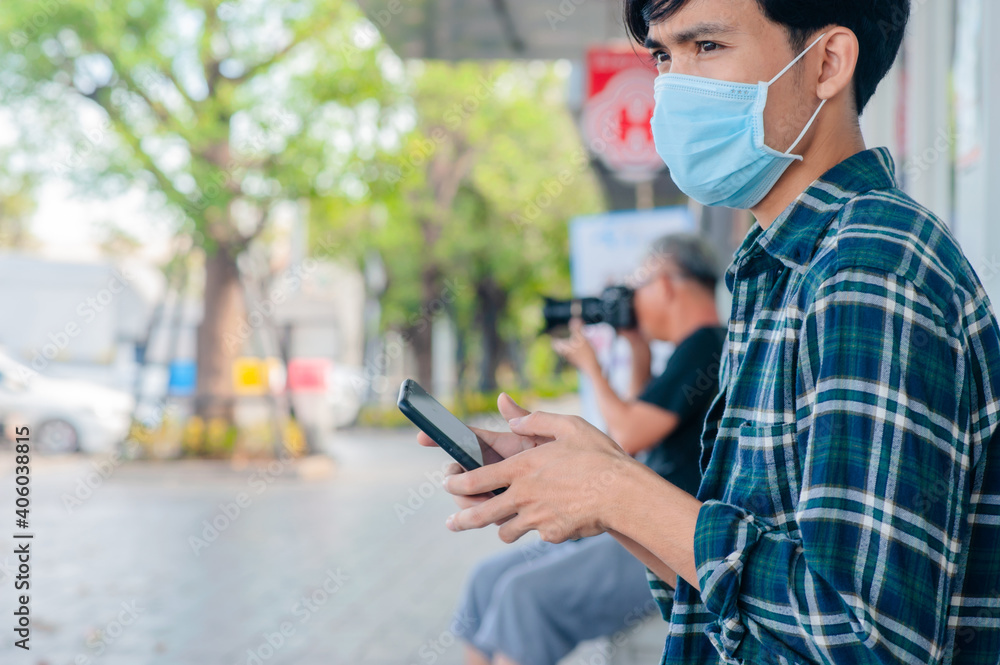 Asian man wear medical mask use smartphone social distancing lifestyle new normal Asian man wear medical mask use smartphone social distancing lifestyle new normal