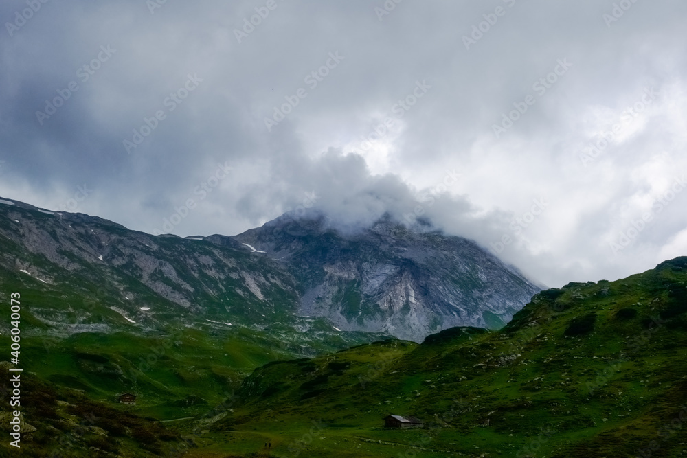 green landscape with high mountains and rain clouds green landscape with high mountains and rain clouds