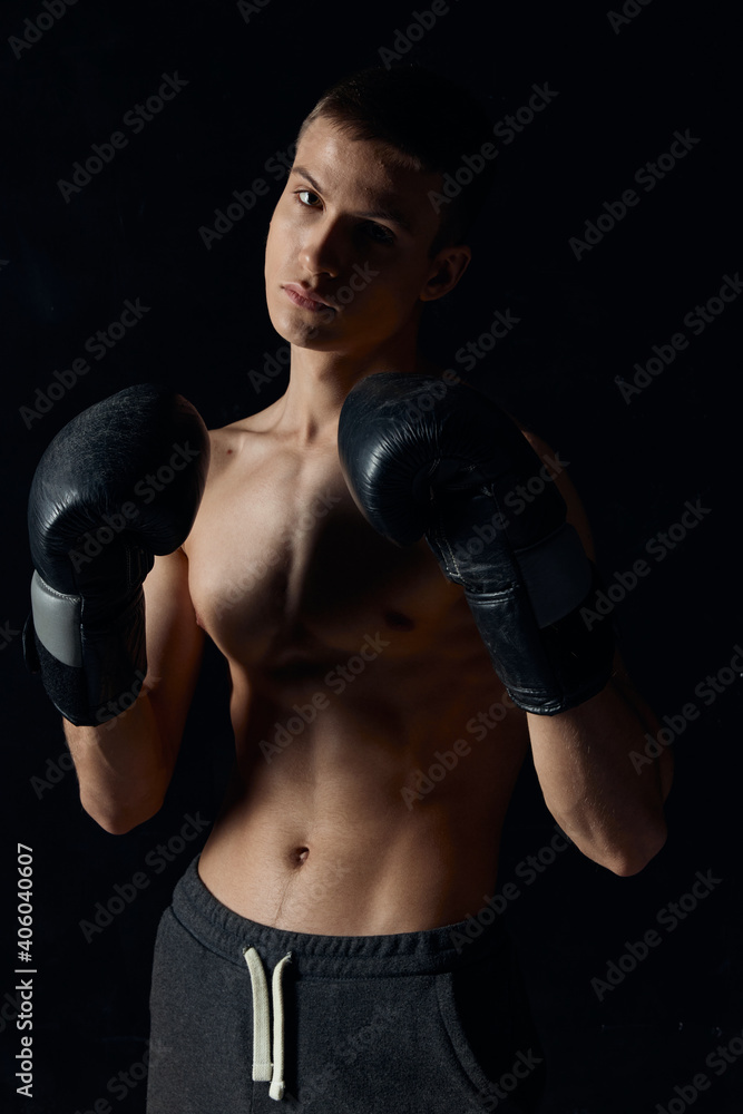 sports guy on a black background in boxing gloves inflated torso cropped view Model Copy Space