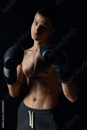 sports guy on a black background in boxing gloves inflated torso cropped view Model Copy Space © SHOTPRIME STUDIO