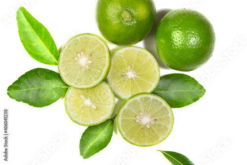 Fresh green Thai lemons  whole and sliced       with their leaves  placed on a isolated white background. With copy space.