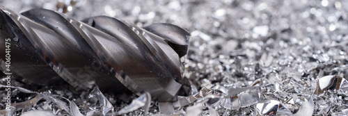 Panoramic image. Silver end mill cutter with metal shavings. Processing of ferrous metals in a factory photo