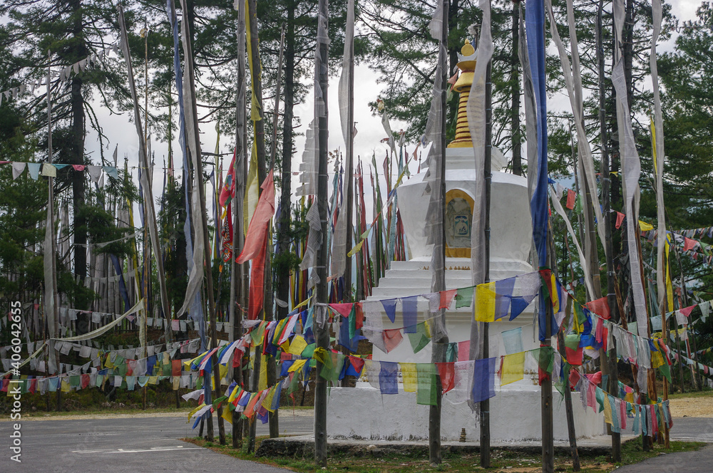 Buddhist chorten or stupa with traditional prayer flags and banners at a pass in the mountains near Bumthang in central Bhutan