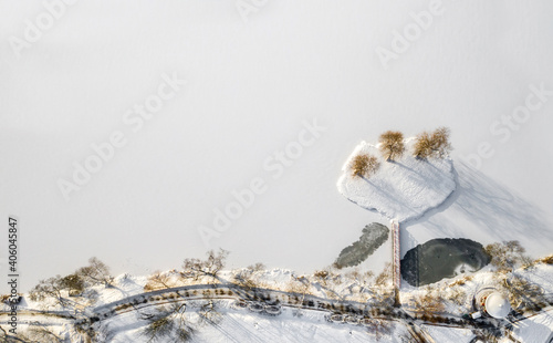 an island on a lake with a bridge in the Winter Loshitsky Park. Minsk, Belarus photo