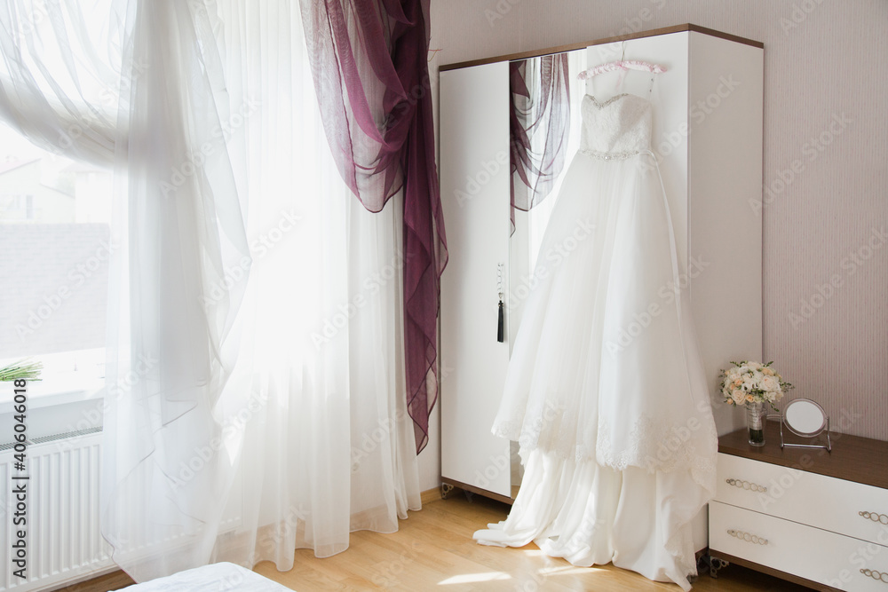 Bride's wedding dress is ready and waiting for the Bride and wedding ceremony in a Bride's room Bride's wedding dress is ready and waiting for the Bride and wedding ceremony in a Bride's room