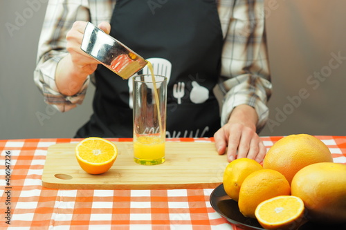 A young man pours freshly squeezed citrus juice into a