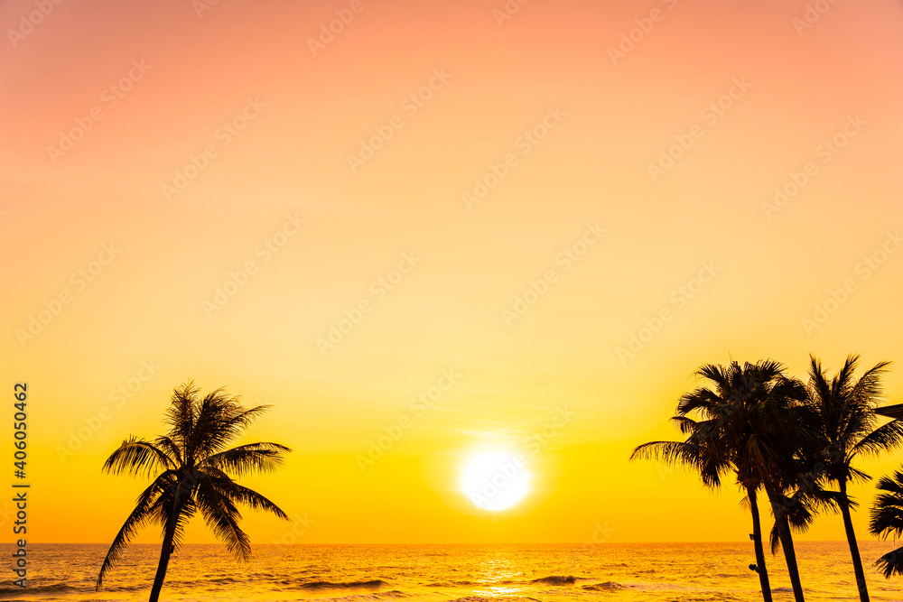 Beautiful tropical beach sea ocean at sunrise or sunset with palm tree