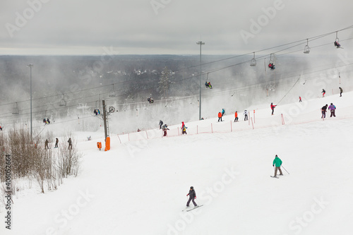 Chairlift with sportsmen on the slopes of snow park in Russia.