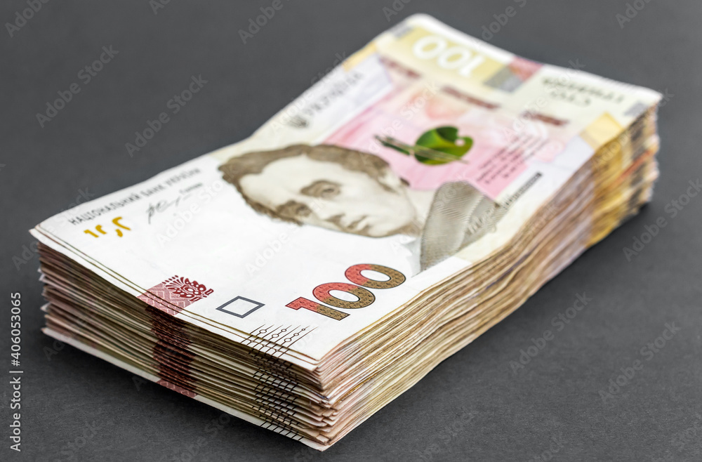 Stack of ukrainian one hundred bills on grey background. Stack of ukrainian one hundred bills on grey background.