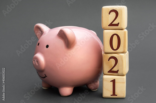 Cubes with numbers "2021" and piggy bank. Savings concept.