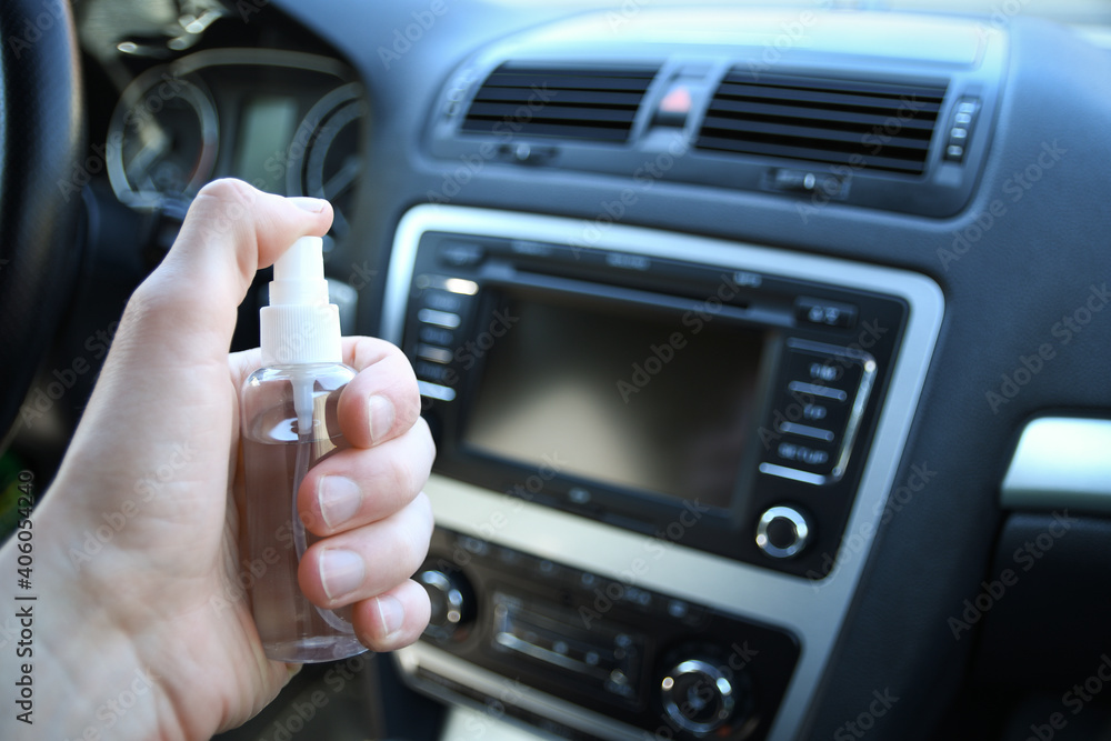 Cleansing car interior and spraying with disinfection liquid. Disinfection of the steering wheel and handles of the car. Coronavirus protection. Virus protection .Disinfecting vihicle inside Cleansing car interior and spraying with disinfection liquid. Disinfection of the steering wheel and handles of the car. Coronavirus protection. Virus protection .Disinfecting vihicle inside