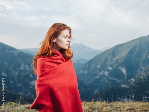 beautiful woman with warm blanket in the mountains and red hair model